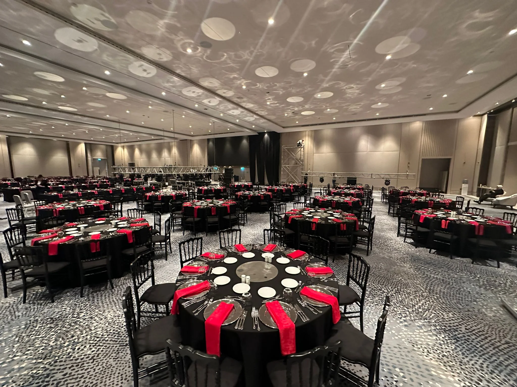 Corporate gala ballroom prepared with round banquet tables and black chairs